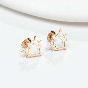 Gros plan sur des boucles d'oreilles cœur en or rose avec motif filigrane et fermoir