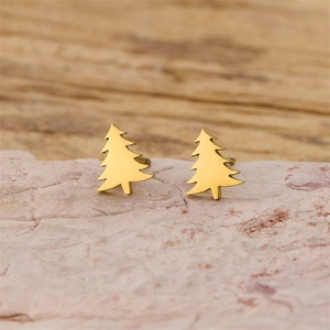 Macro shot of minimalist gold stainless steel Christmas tree studs on stone