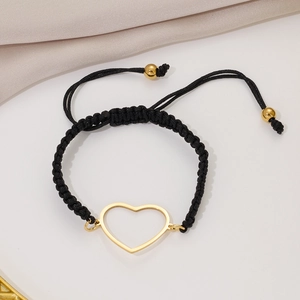 Black braided rope bracelet with gold hollow heart charm shown at a 45-degree angle