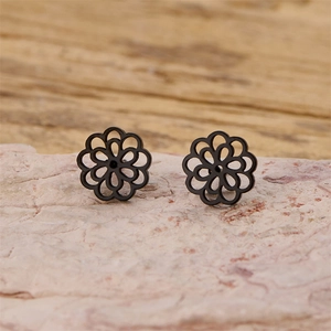 Macro shot of black cutout mandala flower stud earrings with detailed petal layering