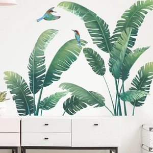 Detail of tropical monstera leaf wall stickers and colorful birds in a living room