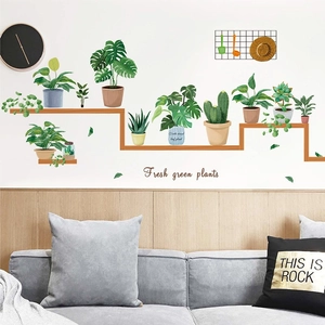 Détail de stickers muraux de plantes nordiques au-dessus d'un canapé gris