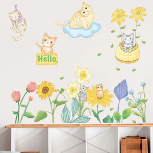 Detailed view of hand-drawn cartoon cat and sunflower wall stickers on white wall