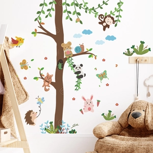 Cartoon forest animals and tree wall stickers decorating a cozy nursery bedroom wall