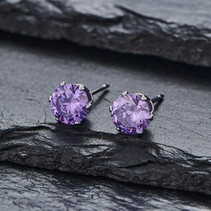 Vue macro de boucles d'oreilles en zircon violet avec serti à six griffes argentées