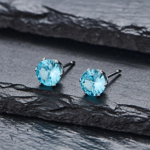 Gros plan détaillé de boucles d'oreilles en zircon bleu ciel sur pierre, sertissage à quatre griffes