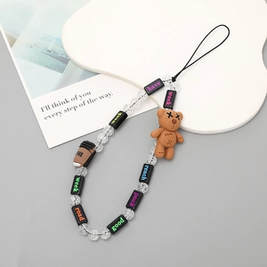 Detailed view of beaded phone strap with brown bear, coffee cup charms and square letter beads