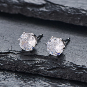 Vue macro de boucles d'oreilles argentées avec zircone ronde sertie de six griffes classiques