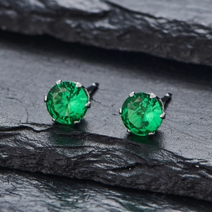 Détail macro de boucles d'oreilles zircon vert émeraude avec monture à quatre griffes