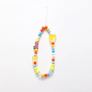 Colorful beaded phone charm with fruit slices, gummy bear and stars on white background