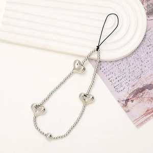 Silver beaded heart phone wrist strap with three metallic hearts on a textured background
