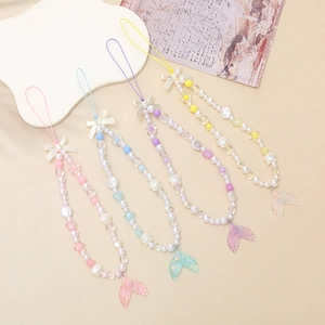 Detail of beaded phone wrist straps with silk bows and glittery mermaid tail pendants
