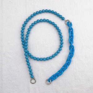 Detail of blue acrylic bead and chunky chain strap with silver metal ring connectors