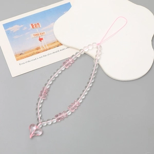 Détail de la dragonne de téléphone en perles d'ours rose avec pendentif cœur transparent