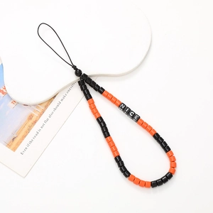 Detail of orange and black beaded phone wrist strap with NICE letter blocks and card