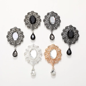 Macro detail of Victorian style alloy pendants with faceted gemstones and drop charms