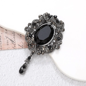 Vintage silver brooch with oval black gemstone and intricate filigree floral design