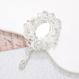 Macro detail of a vintage silver brooch with a large oval crystal and teardrop pendant
