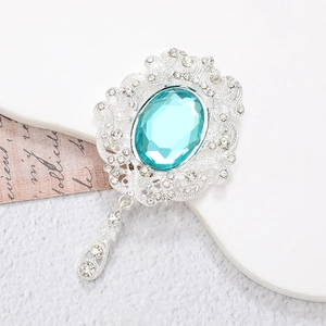 Detail of vintage silver pendant with blue gemstone and rhinestones on a white stand