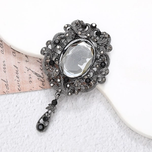 Detailed macro view of vintage rhinestone brooch with feminine relief and grey crystal drop