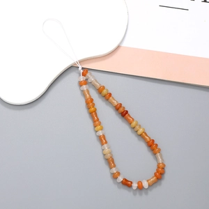 Detail der orange-cremefarbenen Perlen-Handykette mit knochenförmigen Perlen