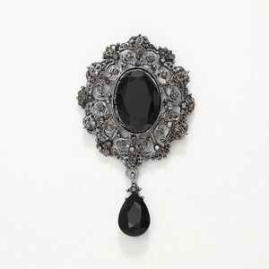 Vintage gothic brooch with black oval gemstone and teardrop pendant in silver metal