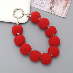Close-up of plush red faux fur ball phone strap with silver metallic clasp and beads