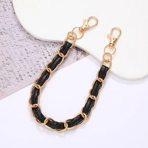 Detail of elegant black leather and gold metal interwoven chain with lobster clasps