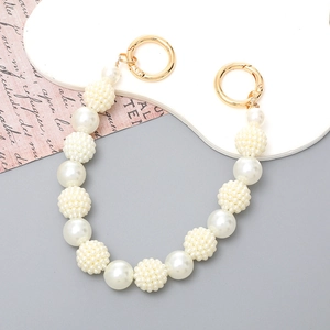 Detail of high-gloss white pearl handbag chain with gold spring ring clasps and bead clusters