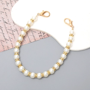 Detailed shot of cream pearl chain with gold rhinestone spacers and lobster clasps