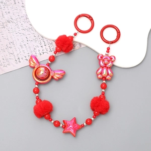 Macro shot of red beaded phone chain with fuzzy pompom and metallic star charms