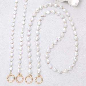 Detail view of Baroque pearl crossbody chain with gold beads and spring ring clasps