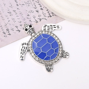 Macro detail of a blue enamel sea turtle pendant with crystal rhinestones on vintage paper