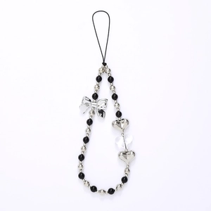 Detail of beaded phone strap with silver bow and heart charms on black cord