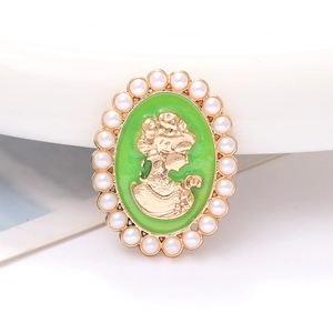 Detalle de colgante camafeo vintage con esmalte verde, perfil dorado y borde de perlas
