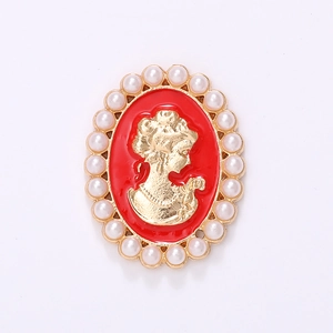 Detalle frontal de un broche de camafeo vintage con esmalte rojo y perlas blancas