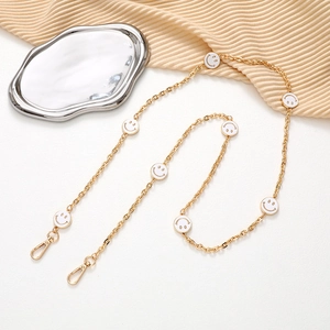Golden crossbody phone chain with white smiley face charms and lobster clasps