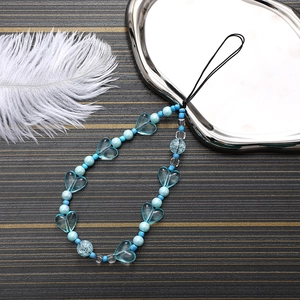 Detail of blue beaded phone strap with acrylic heart and marble beads on a tray
