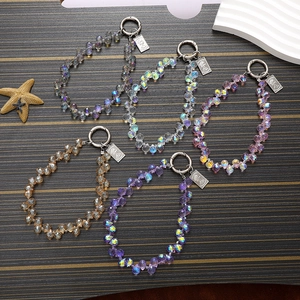 Detail of five colorful crystal beaded charms with spring ring clasps and metal pendants