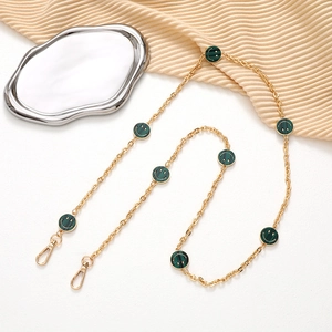 Detail of gold link chain with green smiley charms and metal lobster clasps for phone or bags