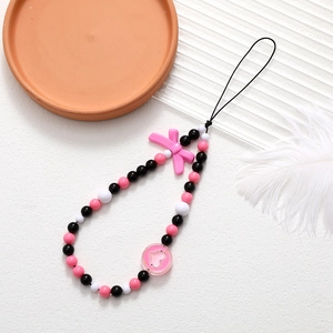 Detailed shot of beaded phone lanyard featuring pink resin bow and hollow heart charm