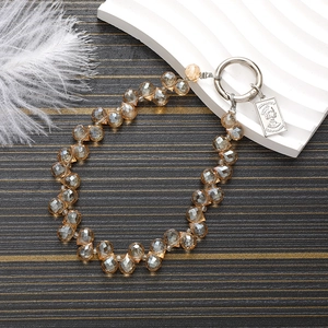 Macro shot of amber faceted glass beads with a silver coin charm and metal spring clasp