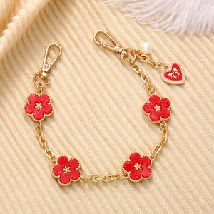 Gold chain accessory with red enamel flower charms and pearl drop for phone or bag