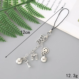 Silver metal keychain with LOVE pendant, Eiffel Tower, and beads on grey background