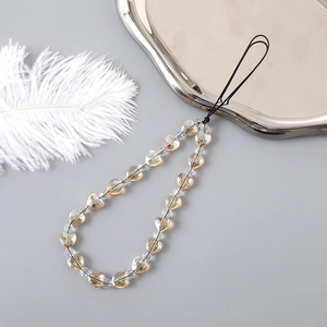 Detailed macro view of beaded phone strap with amber heart charms and clear crystals