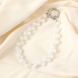 Close-up of elegant iridescent white beaded phone charm with polished silver metal clasp
