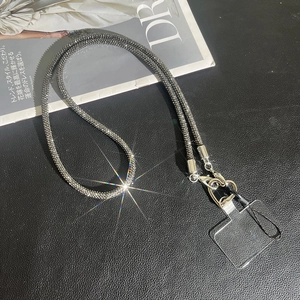 Detail of crossbody phone chain with rhinestone inlay and silver lobster clasp on dark texture