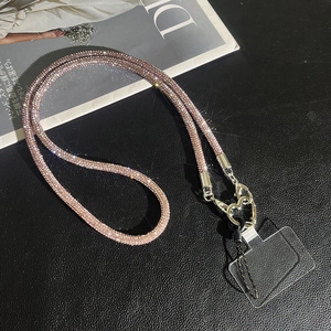 Elegant rose gold rhinestone mobile crossbody strap with heart clasp on leather texture