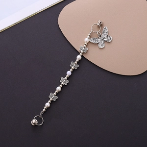 Detailed macro view of butterfly metal pendants and faux pearl beads for phone cases