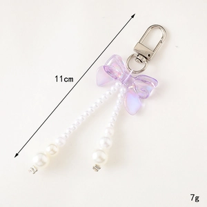 Porte-clés élégant à nœud violet avec perles blanches et fermoir mousqueton argenté